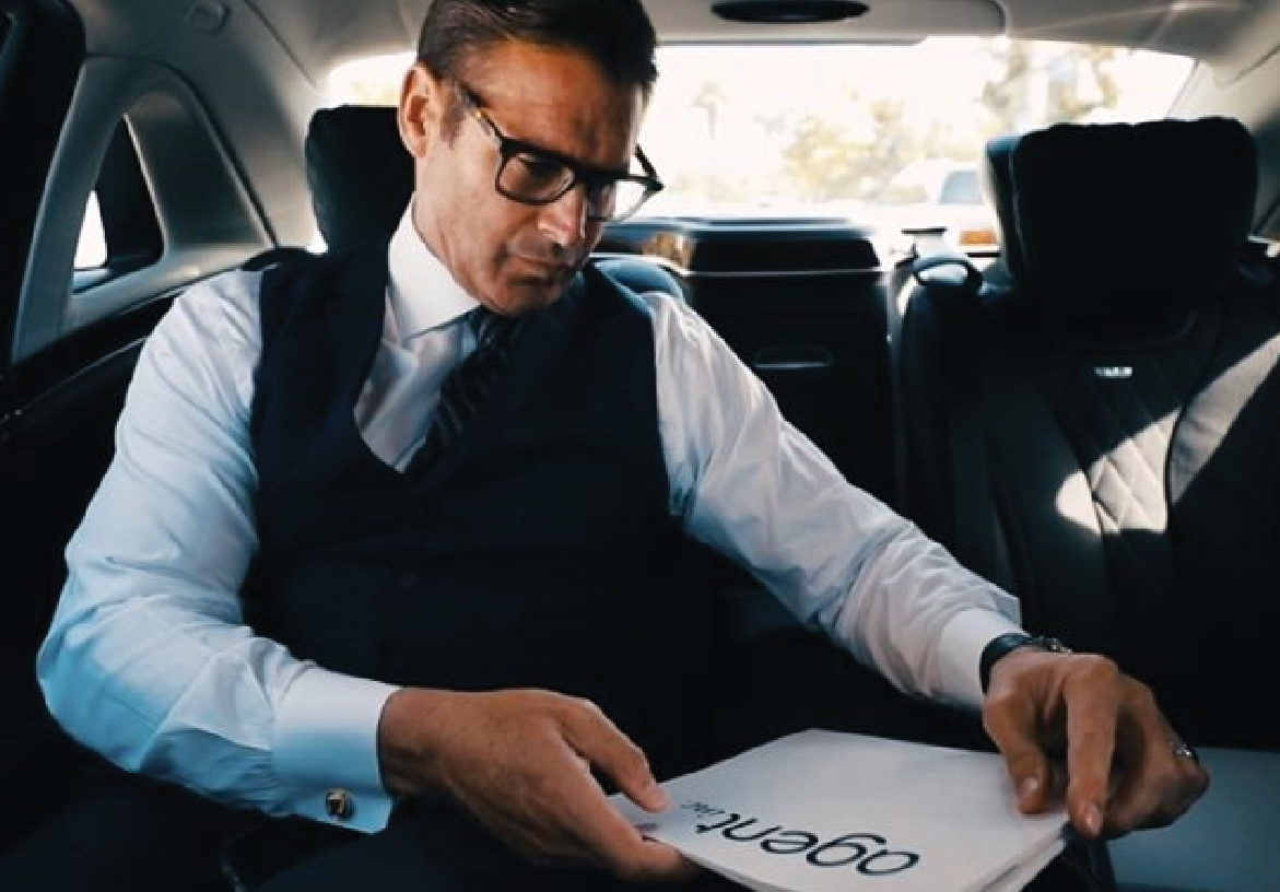 Professional real estate agent from AGENT INC. in a car, reviewing documents with the Agent Inc. logo visible, conveying a sense of on-the-go service.