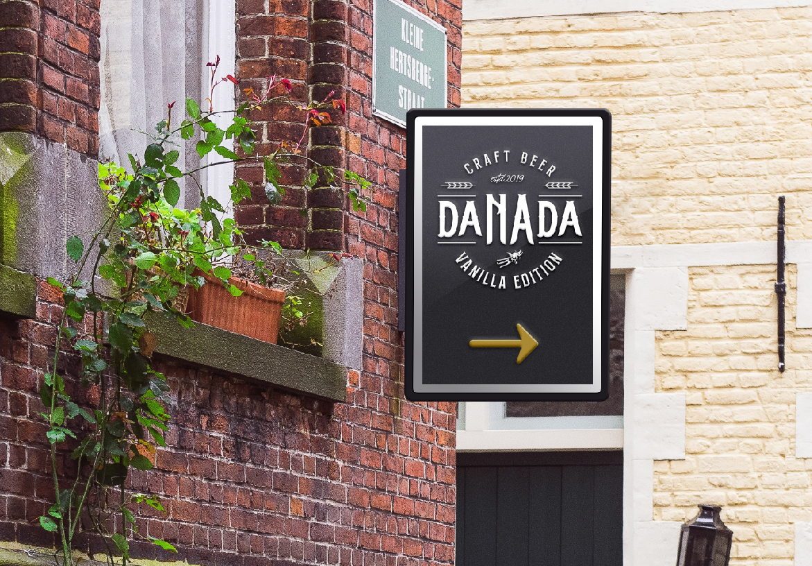Outdoor hanging signage for Danada Craft Beer mounted on a brick building in Porto, featuring the Vanilla Edition branding in a classic black and white style.