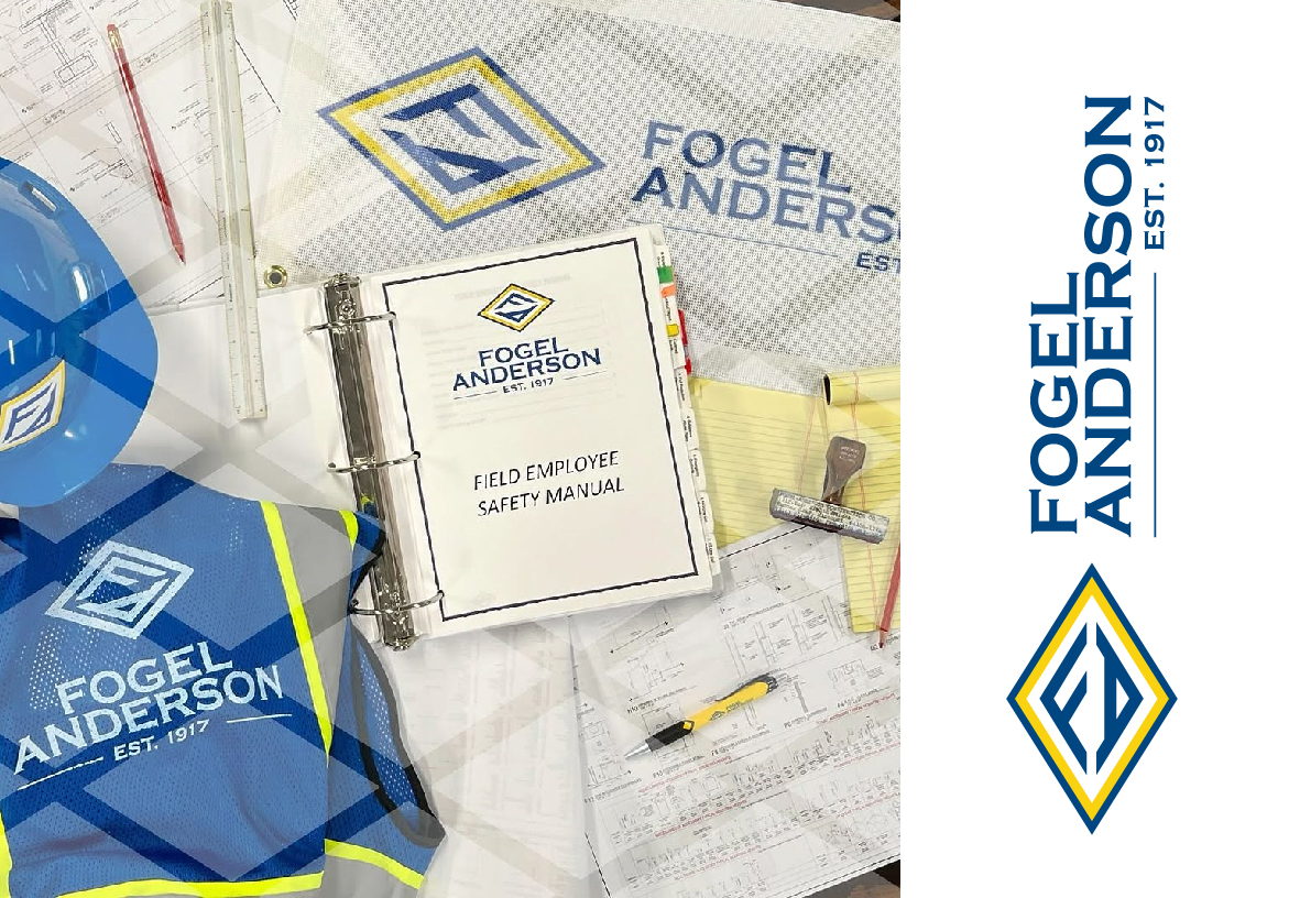 Close-up of Fogel Anderson branded safety manuals and blueprints displayed next to blue and yellow high-visibility construction vests.