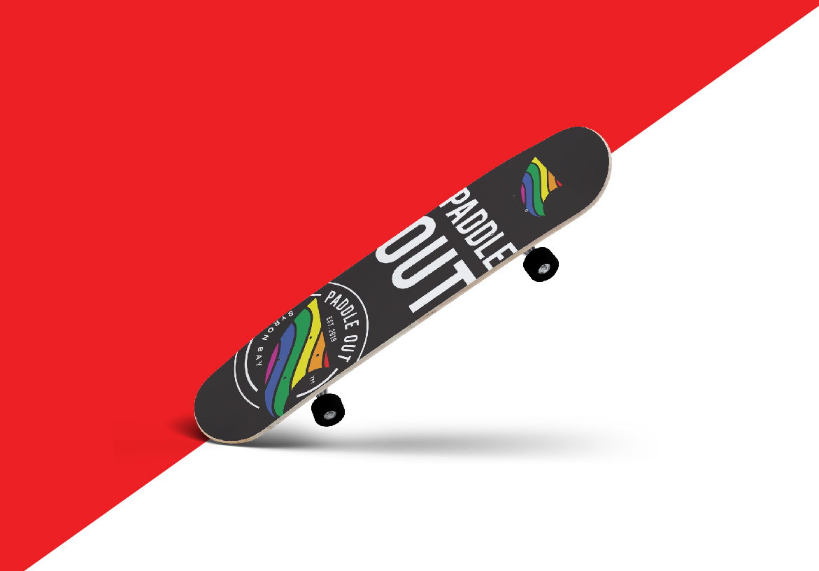 Bottom view of a skateboard deck customized with Paddle Out branding, showcased against a bold red background.