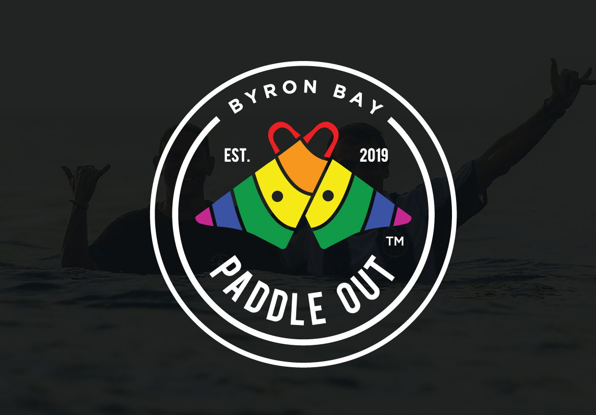 The Paddle Out Byron Bay circular emblem displayed on a textured black background, emphasizing the brand's established date of 2019.