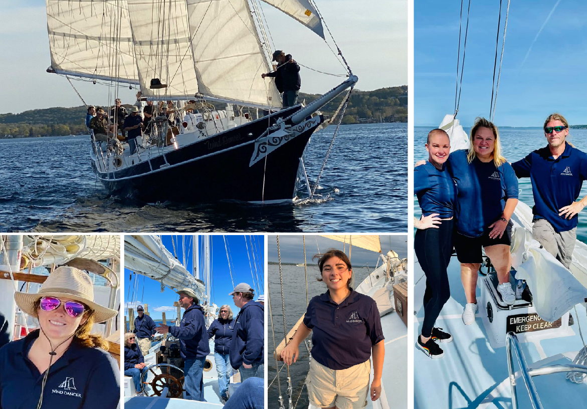 Happy groups of friends and families posing on the deck of the Wind Dancer schooner during a sunny day tour in Traverse City.