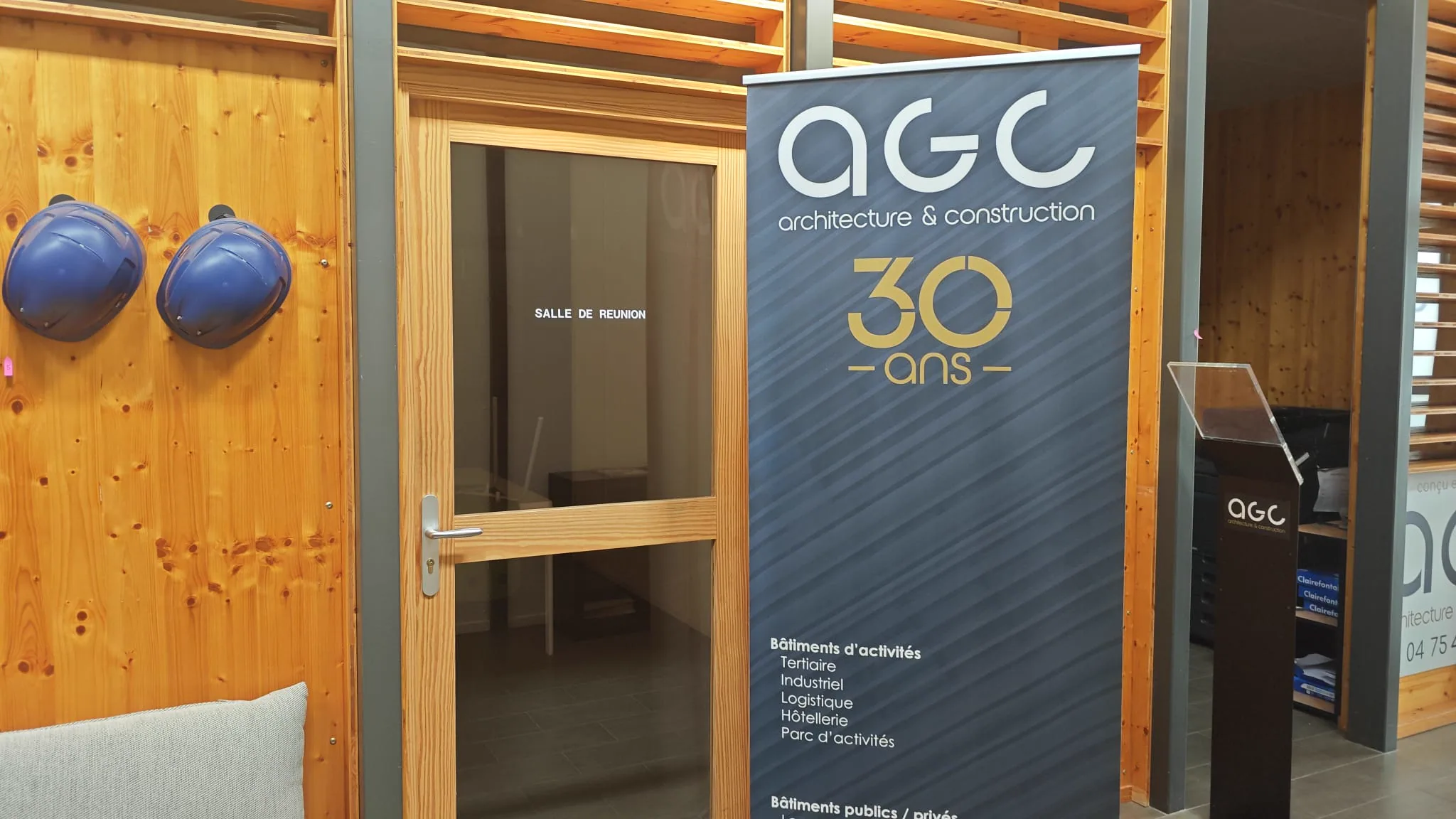 AGC anniversary banner beside the meeting room in the timber-lined office