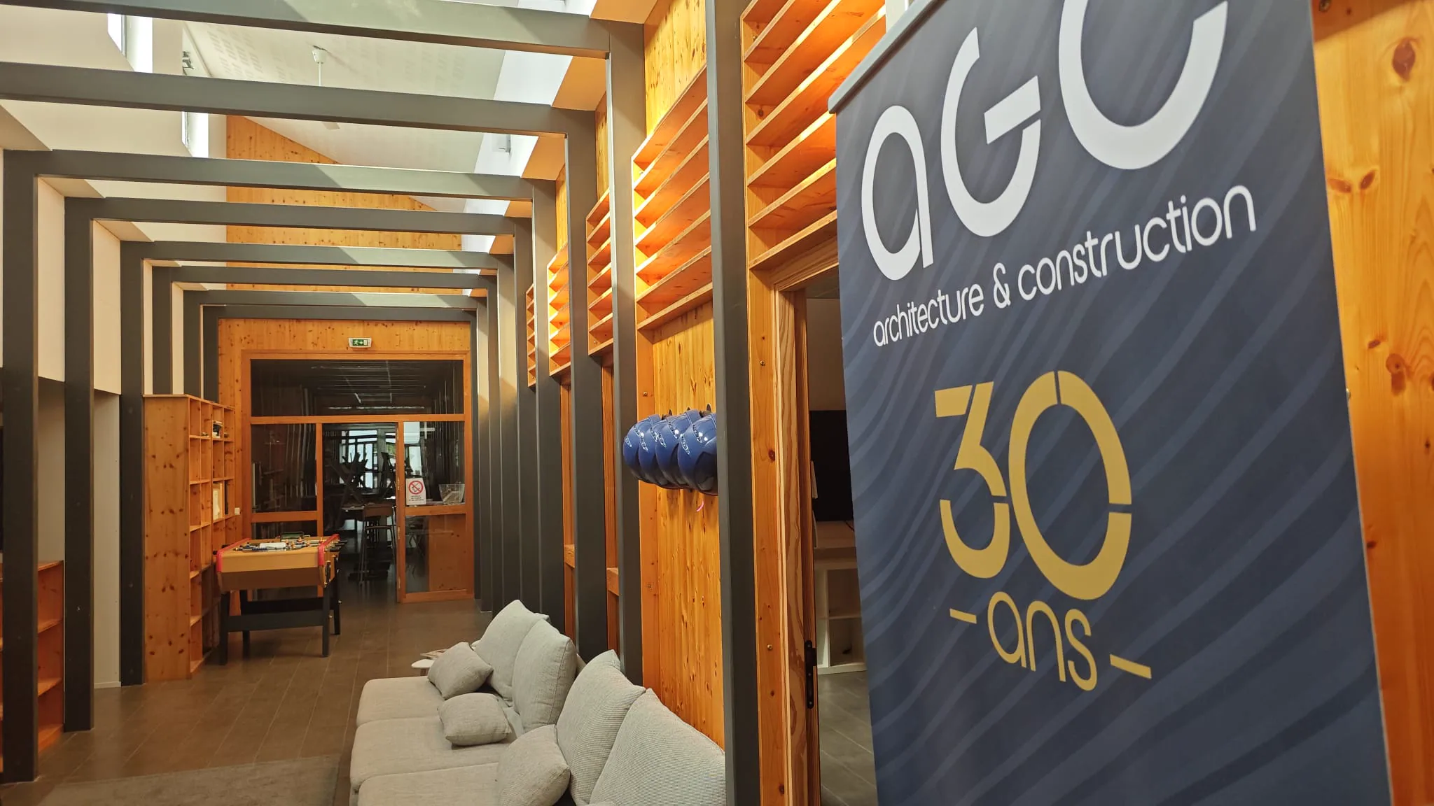 AGC office interior with repeating steel frames, timber walls and the 30 years anniversary banner