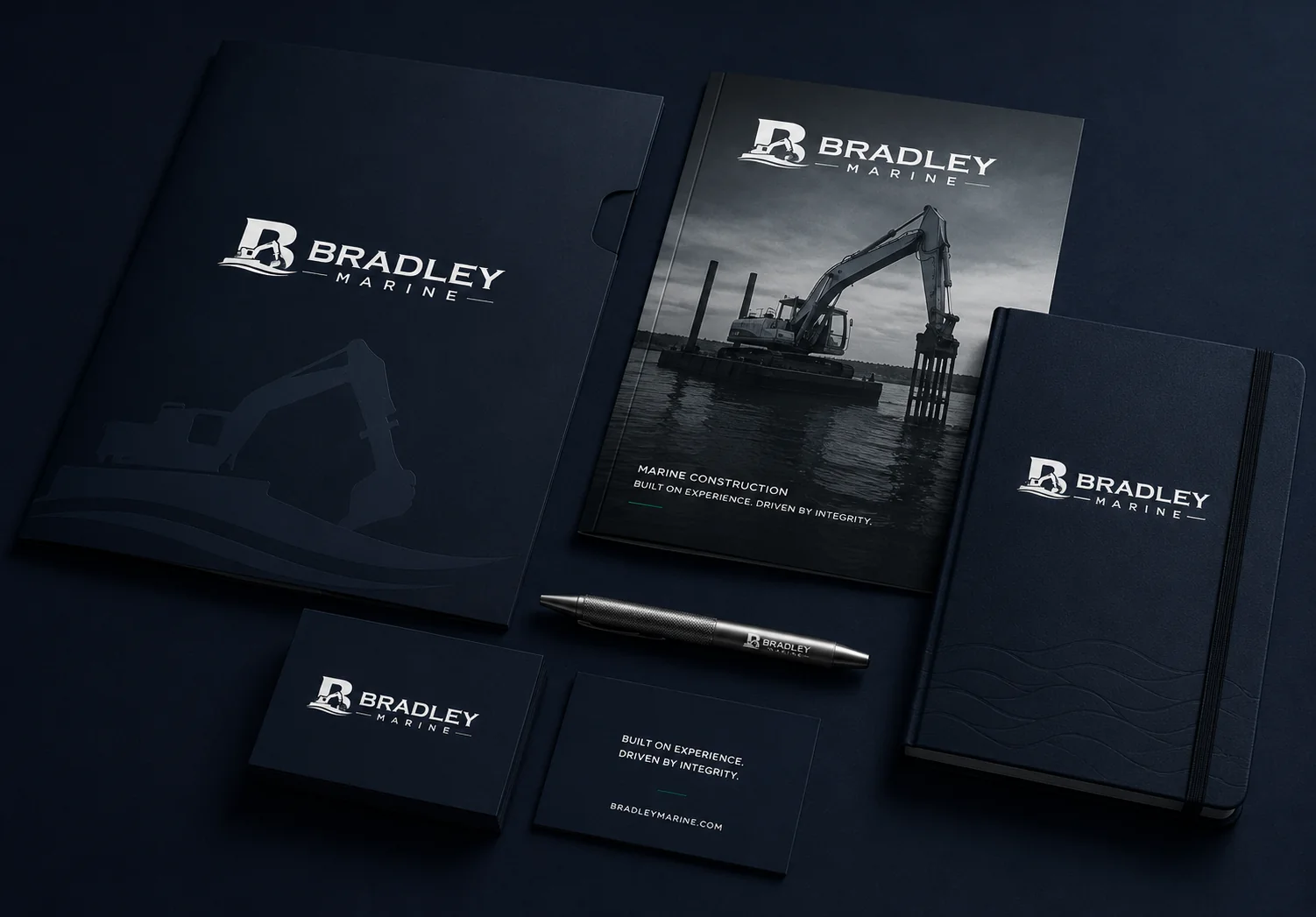 Bradley Marine dark navy collateral system with folder, brochure, notebook, cards, and pen