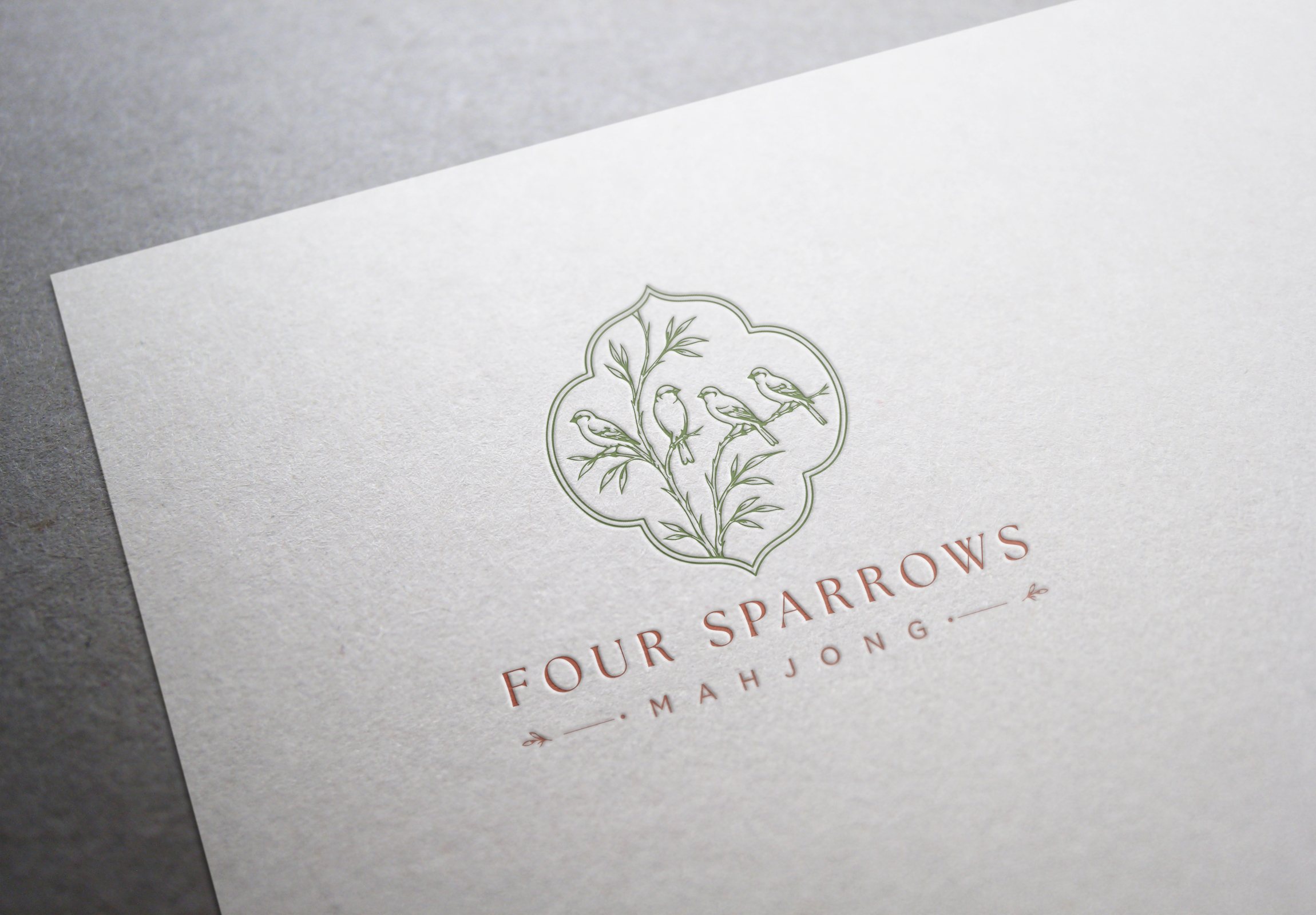 Letterpress detail of the Four Sparrows Mahjong logo printed on textured ivory paper