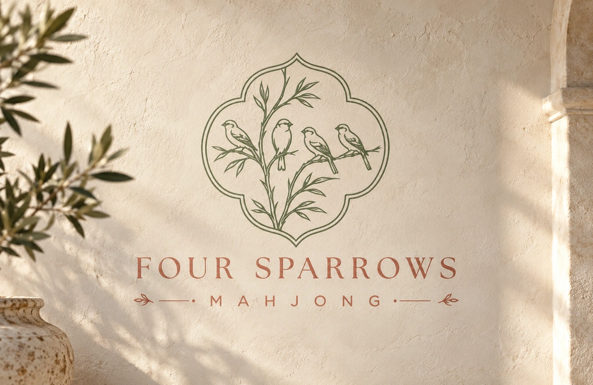 Four Sparrows Mahjong wall logo in warm light with olive branches and terracotta lettering