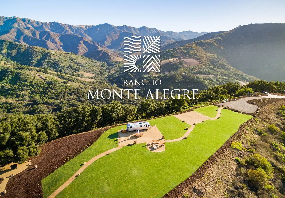 Aerial drone view of green home site at Rancho Monte Alegre with logo on blue and green color blocks