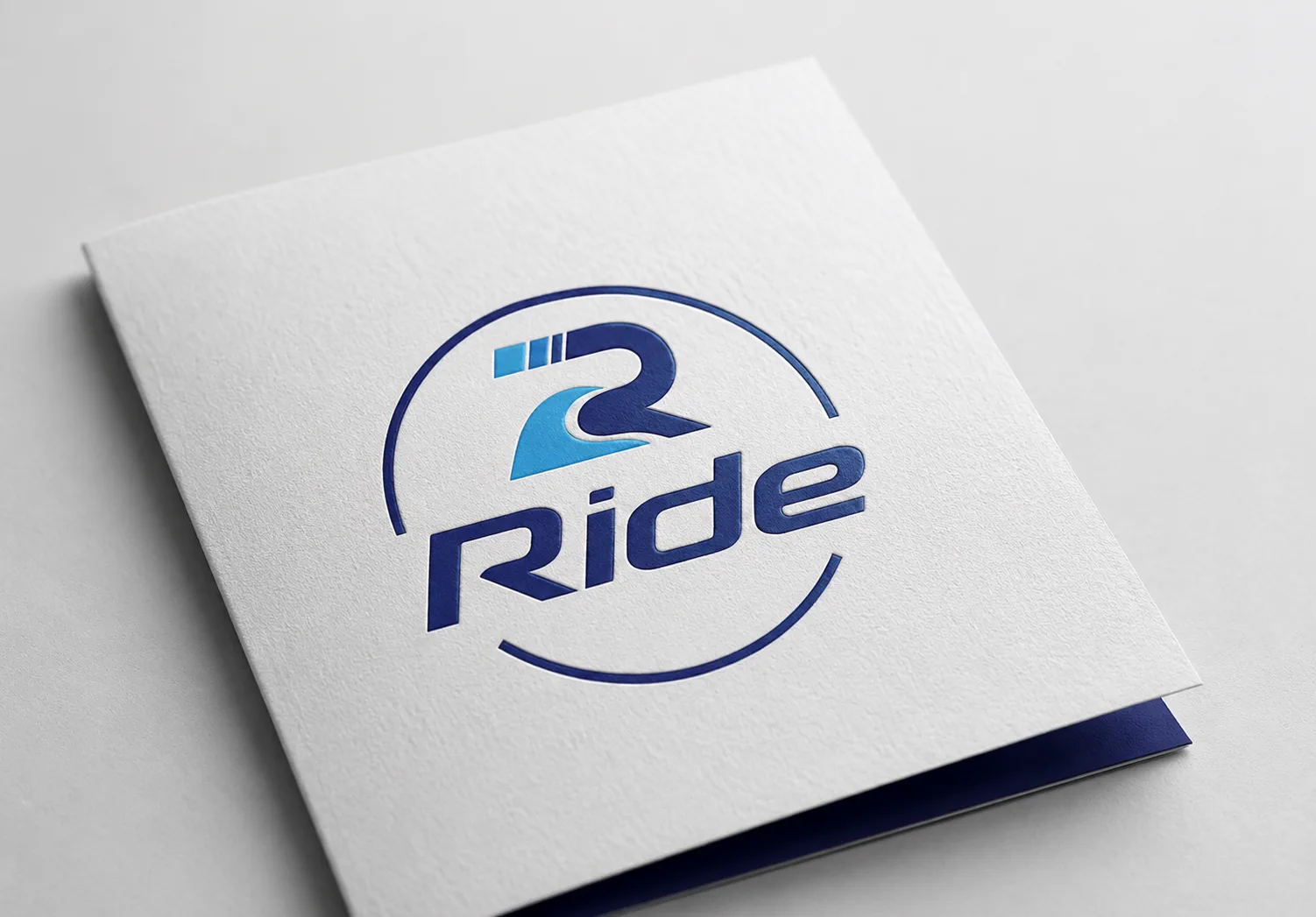 Ride R-wave logo printed on a folded white brand folder with navy edge detail