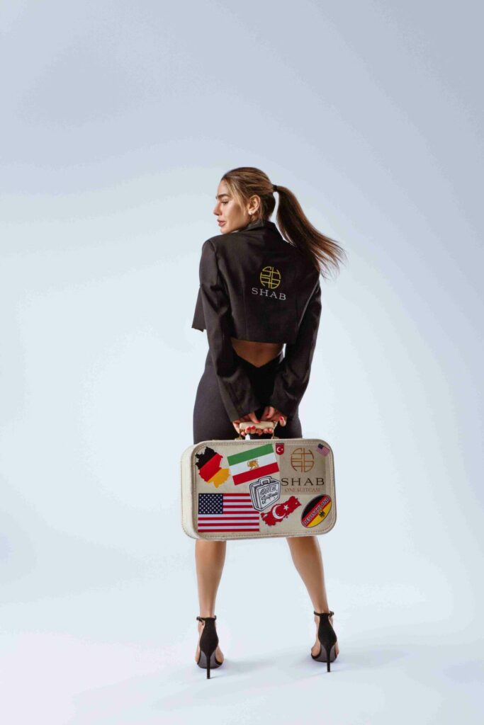 SHAB press image with gold logo on jacket and One Suitcase branded case