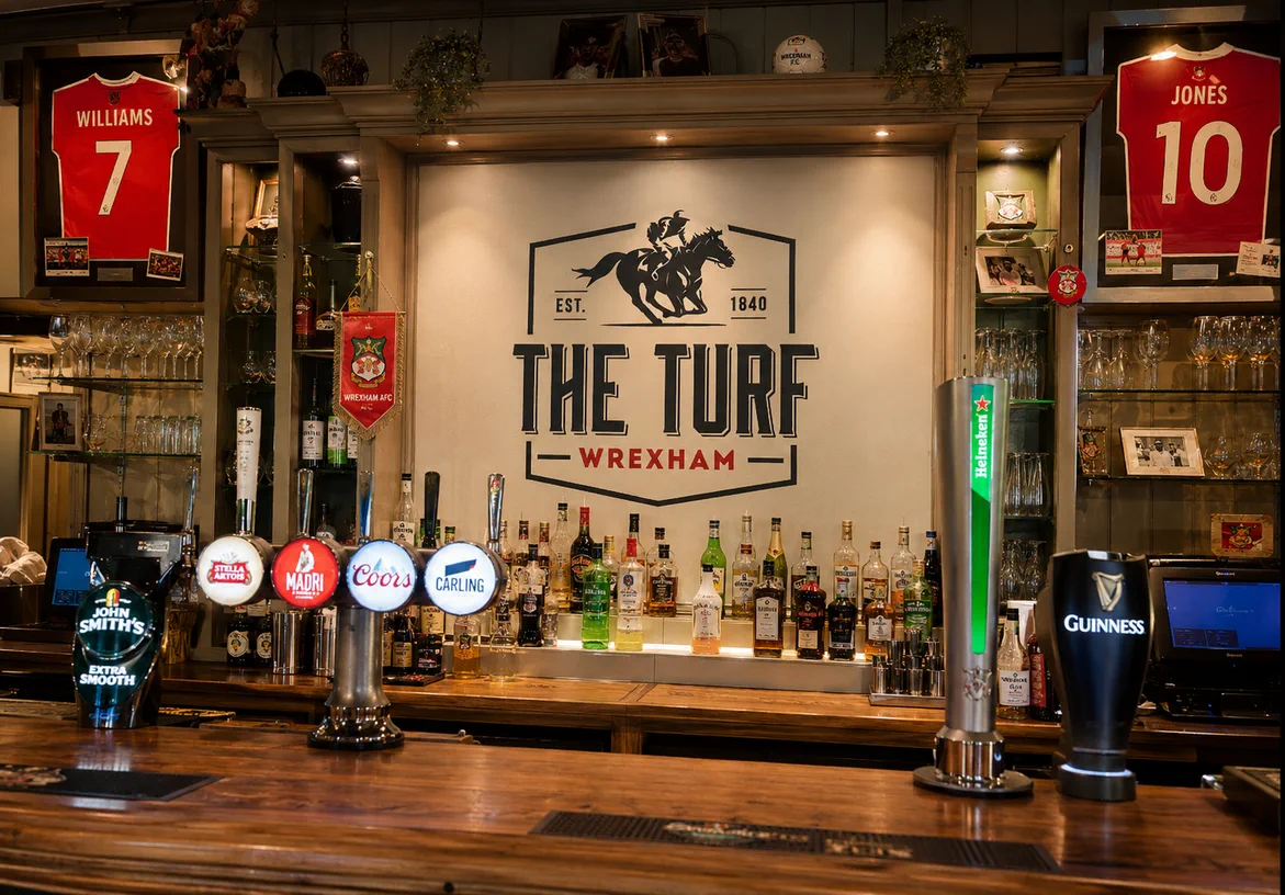 The Turf logo displayed behind the bar inside the Wrexham pub interior