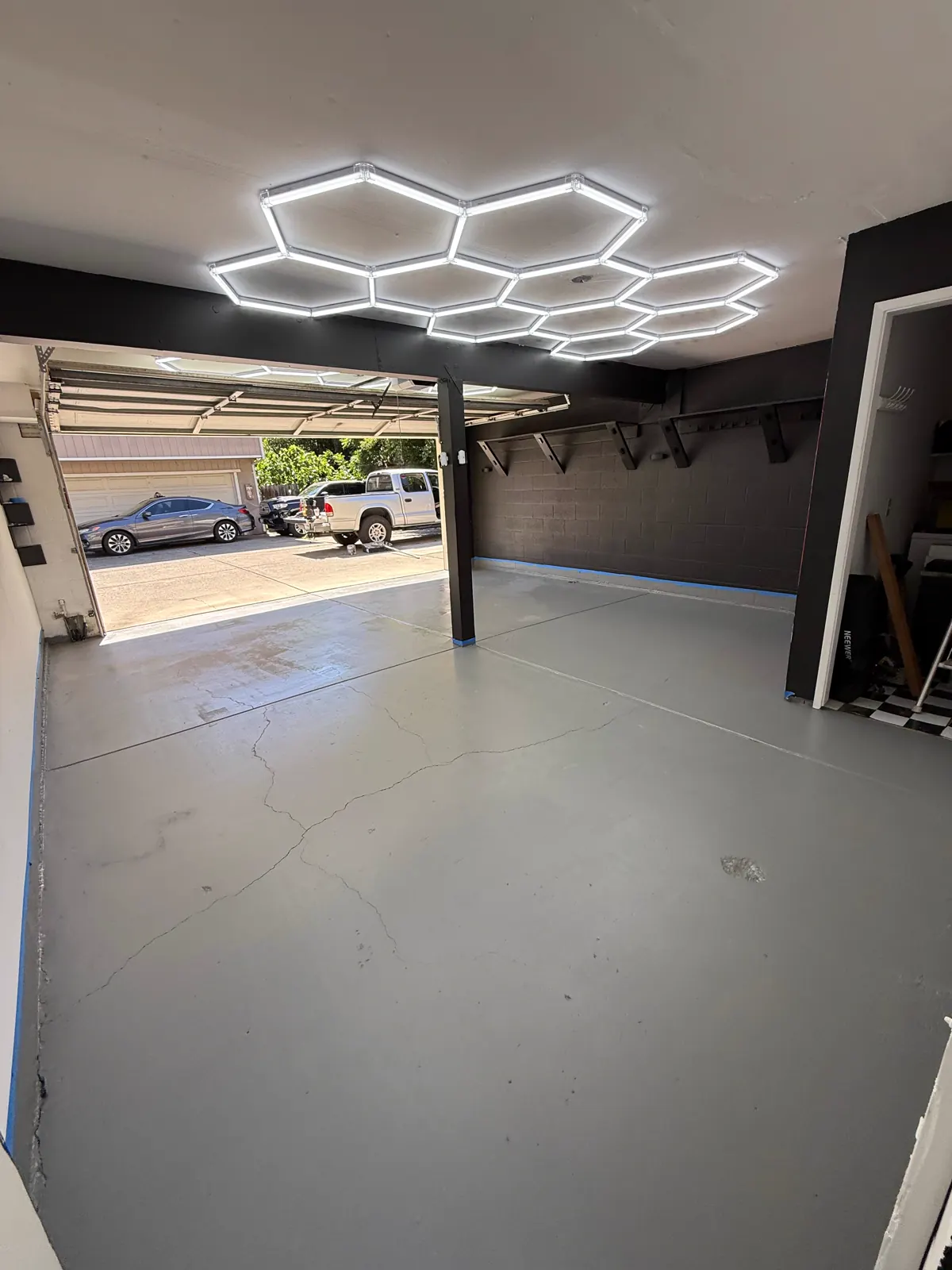 Wake Up Sports studio floor finish with hex ceiling lighting and black wall surfaces